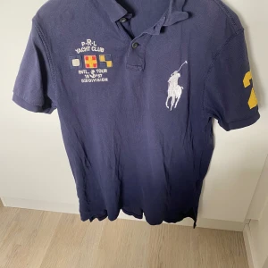 Polo Ralph Lauren - En stilren vintage polo från Ralph Lauren som är perfekt inför sommaren. Varan är hel och är i gott skick. Storlek M. 