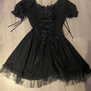 Fin emo klänning - nyskick. Det är en dragkedja i ryggen men man kan justera passformen med hjälp av korsettsnörena fram. Bra kvalitet på tyget