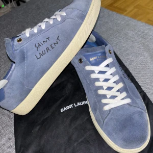 Saint Laurent Sl/06 sneakers  - Hej. Säljer ett par väldigt unika och sällsynta ysl skor i marinblå färg. Mocka skor som är otroligt vackra och snygga inför sommarens ljus. Perfekt skick: 9/10, dustbags medföljer. Givetvis äkta då fejks tillverkar ej i denna färg. 