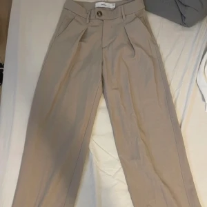 Kostymbyxor  - Beiga kostymbyxor med låg midja!  Beställde fel storlek så aldrig använda.  