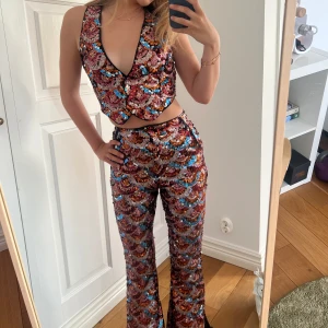 Paljett set! - Setet är från Nastygal UK och aldrig använd. Byxorna är i storlek 34 och toppen i Storlek s! Lappen finns också kvar på outfiten.   Byxorna kan säljas separat då jag har två exemplar!  🪩🪩🪩  