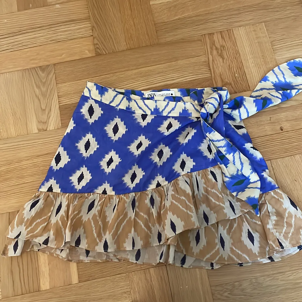 Flerfärgad omlott kjol med rosett och volanger nertill. Super somrig och jättefin😍 (Minikjol) använd typ 1 gång😊. Kjolar.