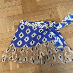 Flerfärgad omlott kjol med rosett och volanger nertill. Super somrig och jättefin😍 (Minikjol) använd typ 1 gång😊