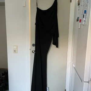 Svart långklänning - Oanvänd och ny långklänning från Asos. Nypris är 1209kr och slutsåld på hemsidan  Väldigt snygg på med armen, perfekt till bal eller liknande!