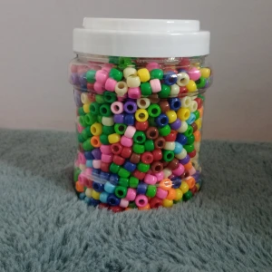 Pärlor - En burk ful av färglada pärlor 