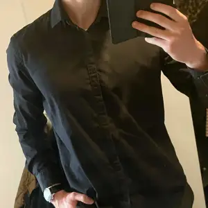 Stilren svart Tiger of Sweden skjorta med dolda knappar. Tunnare modell som passar perfekt till sommaren. Storlek 42, M/L. Bra skick. Nypris ~1200kr mitt pris 399kr