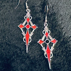 Unika örhängen Spetsiga kors i silver och rött Goth Gotisk Vampyr Rock Metal Alternativ Bundlerabatt  - Örhängen i form av spetsiga kors i silverfärgad metall med röd emalj och en glittrande svart respektive röd kristall i mitten. Allergivänliga krokar. 7 cm långa och 2 cm breda.  Nytillverkade av mig. Anslående och unika. Bundlerabatt. 