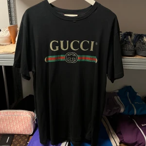 Gucci Logo T-shirt - WTS Gucci Logo T-shirt  Storlek: Medium Skick: 7/10, se hål, ett ska vara där Pris:    Vänligen hör av dig vid frågor eller önskemål om mer bilder osv.