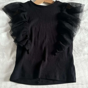 Svart tyg armad topp - Bra skick.ren,har inte andvänt,storlek är 134-140