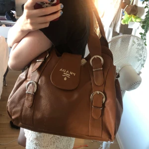 Brun pradaliknande väska - Så fin! Använt endast ett par gånger så superbra skick 💗 skriv för fler bilder! Pris kan diskuteras vid snabb affär