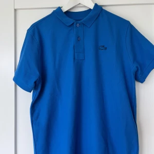 Lacoste piké  - Använd en gång,10/10 skick. Super skön och bra material. Härlig blå färg. 