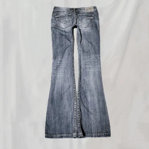 Lågmidjade jeans - Midja:78 innerben:85 Lågmidjade jeans I bootcutmodell. Storlek w28, stora på mig så håller upp på bild. Lite smånötta på vissa ställen, ex.fickor. Något nötta fotändar. Överlag bra skick🤍