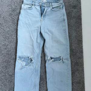 Ett par högmidjade jeans med hål i knäna från Gina Tricot i storlek 34. Använda någr gånger 