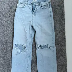 Ett par högmidjade jeans med hål i knäna från Gina Tricot i storlek 34. Använda någr gånger 