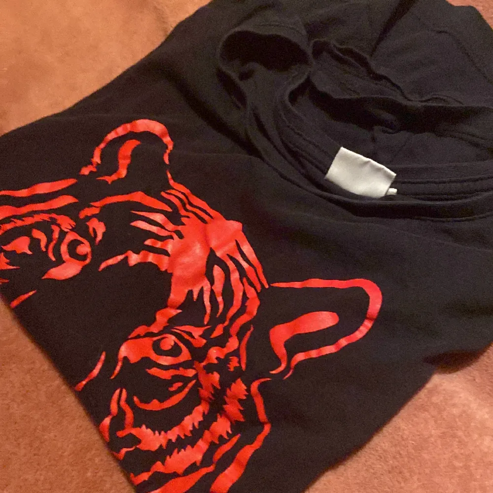 En fin svart tröja med en röd tiger på, fint skick och säljer pga gör liten stl. M . T-shirts.