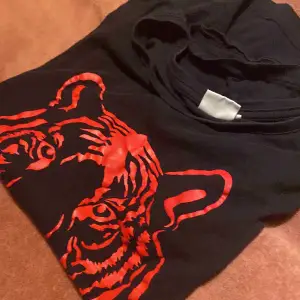 En fin svart tröja med en röd tiger på, fint skick och säljer pga gör liten stl. M 
