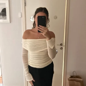 Gina tricot off shoulder topp - Off shoulder topp från Gina i en off white/beige fin färg. Stl Xs, och har utsvängda armar runt handlederna, materialet är mesh, men flera lager så den är inte genomskinlig, den är i nyskick 