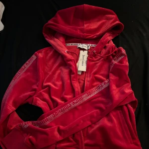 Vintage Juicy Zip-hoodie - Går inte att hitta längre, har prislapp kvar. Klassisk röd Juicy Couture hoodie, fick den av mamma som aldrig använde den. Den har coola tumhål också som gör att ärmarna inte åker upp när man har på sig den. Storlek XL men passar M/L fint
