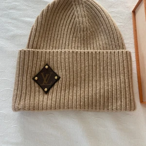Louis Vuitton mössa - Bonnet LV beanies beige mössa. Skick:10/10 oanvänd. Orginalförfackning, påse och kvitto medföljer. 
