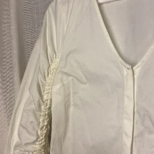 Vit blus  - Vit blus med detaljer i ärmarna från  NA-KD!