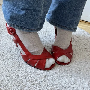 Röda klackskor  - Superfina röda klackskor. Ena spännet är endast metall men i övrigt är de i bra skick. Pris kan diskuteras. Frakt tillkommer men kan annars mötas upp vid Medborgarplatsen i Stockholm. 