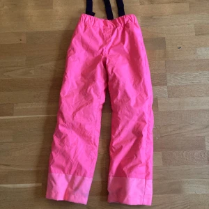 Neonrosa skidbyxa - Varma och sköna vattentäta täckbyxor med borttagbara hängslen. Gott skick. 