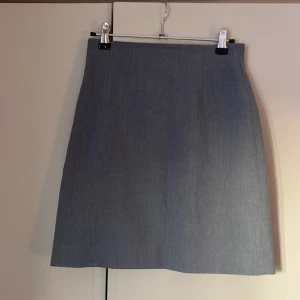 Kort kjol - Kortare kjol från L.O.G.G i fint tunnt kostym-matererial. Dold dragkedja i bak så den är lätt att ta på sig. Storlek 34 och superfint skick, däremot nån lös tråd på insidan men inget som påverkar kjolen på något sätt💗