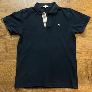 Burberry piké - Säljer denna burberry piké i storlek L men passar M. Tröjan är i väldigt bra skick. Skriv om du har några frågor. Pris kan diskuteras vid snabb affär.