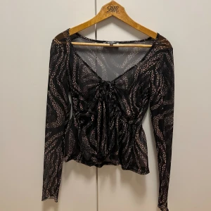 Knytblus från missguided - Skitcool svart mönstrad blus med knyt-detalj fram. Från missguided🩷Använt 1 eller 2 ggr med linne under💕💕