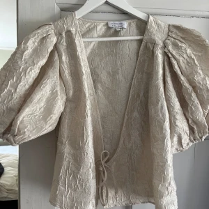 Bluskofta med snörning - Supersöt blus! Knappt använd så mycket bra skick. Köpt från &otherstories men kan inte hitta den där längre. Perfekt till sommaren men inte riktigt min stil 💞