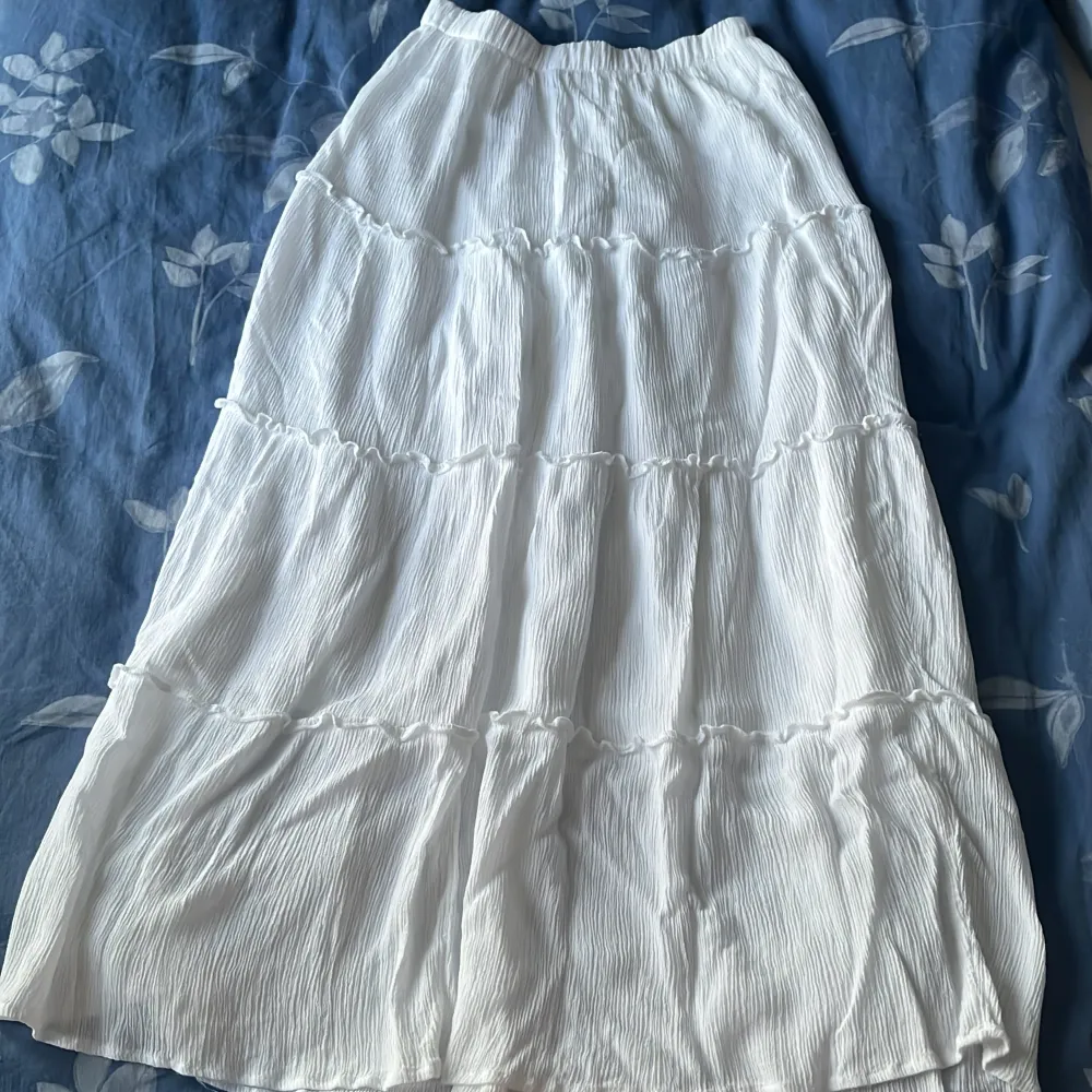 Säljer denna vita långa kjolen eftersom jag inte haft någon användning av den. Är köpt här på Plick och första bilden är lånad av den jag köpte kjolen av! Materialet är lite vågigt och om man har på sig kjolen ser man inte igenom💕Aldrig använd!!. Kjolar.