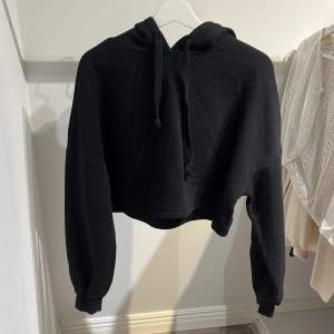 Croppad svart hoodie i strl S från Gina Tricot