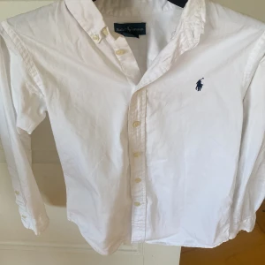 Det Ralph Lauren Skjorta passar 146-160 - 9,5/10 skick riktigt snygg passar bra till sommaren knappats användning och har inga defekter storleken är 12 vilket motsvarar 152 men passar folk som är 146-160 