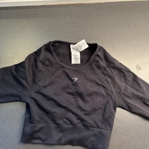 TVÅ PACK GYMSHARK crop tröja - Två superfina gymshark träningströjor! 1 med öppen rygg!!🫶🏼 croppade o långärmade! Säljer enbart då jag har för mycket träningskläder!! Pris ej hugget i sten!
