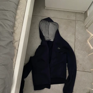 Lacoste zip up hoodie - Lacoste zip hoodie, ganska änvänd men fungerar bra, slimfit och nypris är ca 1200kr