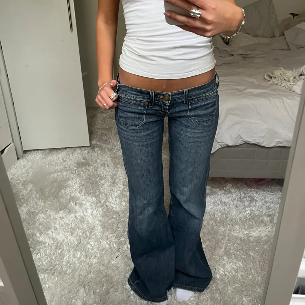 Säljer dessa mörkblåa lågmidjade bootcut jeans från Lee. Midjemått: 75cm Innebenslängd: 79cm. Har du någon fråga är det bara att höra av dig🫶🏻. Jeans & Byxor.