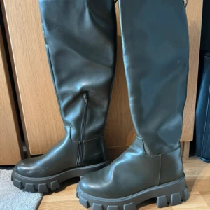 Höga boots med chunky sula  - Gröna höga boots med chunky sula, dragkedja på insidan, från Nakd. De är i stl 38, normal i storleken. Endast använda 1 gång. 