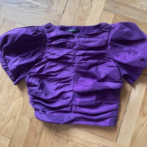 Lila festtopp - Festtopp från Gina tricot. Använd en gång. Puffärm. Kort modell.