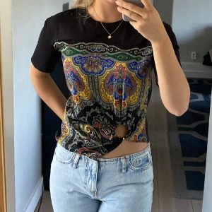 Cool T-shirt topp Sandro - Unik T-shirt från Sandro!! Siden/satin mönster på framsidan med en cool ring vid midjan. Storlek XS