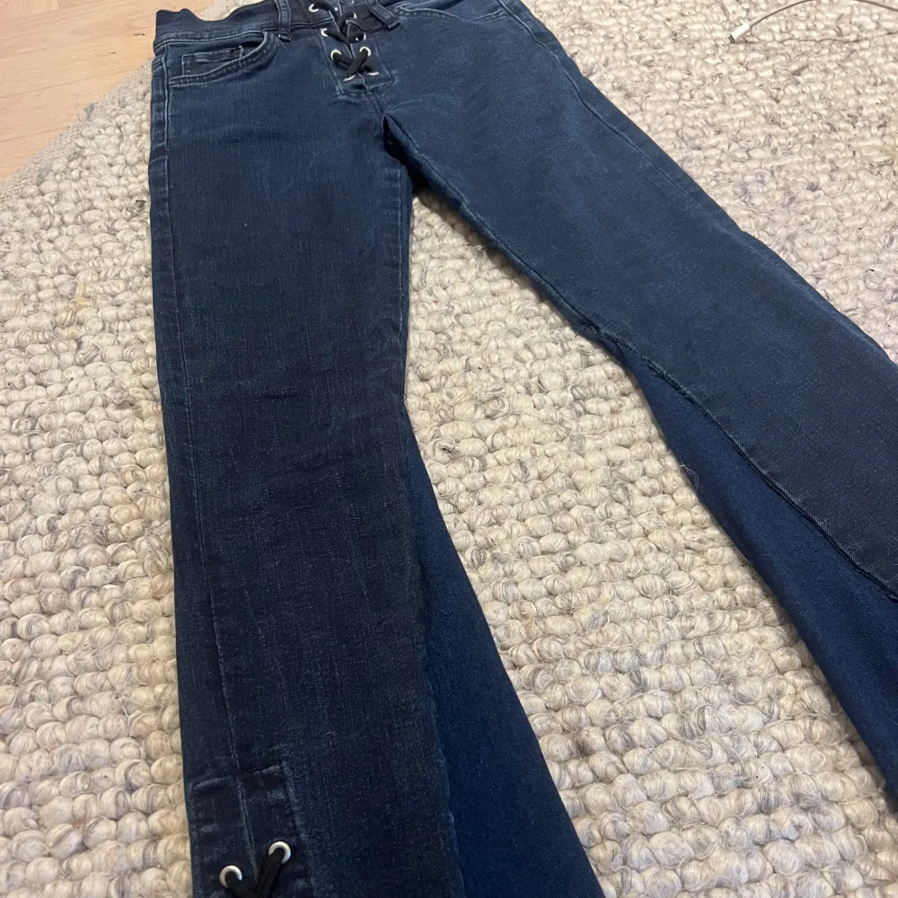 Jättefina mörkblåa utsvängda jeans med snörning både upptill o nertill. Innebenslängden är 69cm o midjemått rakt över är 31cm. Tyväär för små så säljer💓. Jeans & Byxor.