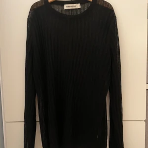 Svart tröja med glitter - Tröja ifrån Carin Wester. Tröjan är svart och har lite glitter i sig. Syns inte så bra på bilden men tröjan är lite genomskinlig. Står i tröjan att det är storlek S men passar också M. 