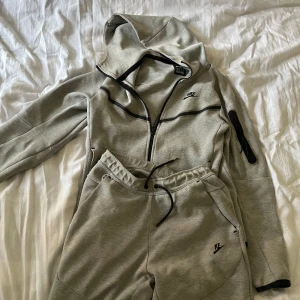 Nike tech fleece grå - En nike dress i storlek S använd ett par gånger lite av nike märket har gått bort på byxorna men annars är de i bra skick  Pris kan även diskuteras vid snabb affär 