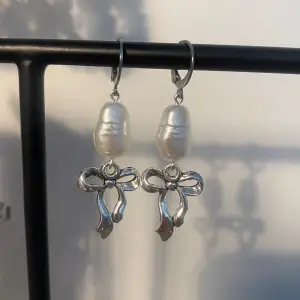 Söta rosettörhängen med vita pärlor.🎀 finns endast 1 par! Delvis rostfria!