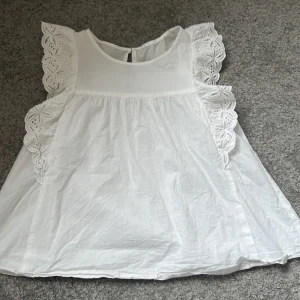 Vit blus! - En fin vit blus med volanger på armarna!💕 Använd ganska många gånger, men skulle säga att den är i ganska bra skick!💕 Prislappen står ej kvar men skulle säga att den är i storlek xxs-xs!💘 Köparen står för frakten!  Pris kan diskuteras!💕
