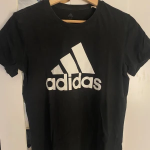 Svart adidas tröja. - Tröjan är i bra skick då den inte använts många gånger, kan användas till att träna i men är ej gjord i ”träningsmaterial” utan som en vanlig  t-shirt.