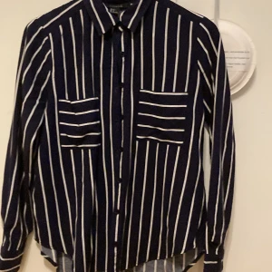 Randig skjorta - En randig skjorta med storlek S, skulle säga att det passar mindre och större också. Den är av rayon men känns mer satin. Kan bli klädd både ner (vardaglig) och upp (festlig). Knappar där fram. 