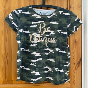 Grön Camouflage t-shirt - Väldigt gullig t-shirt som har används ett fåtal gånger. Normal i storleken.