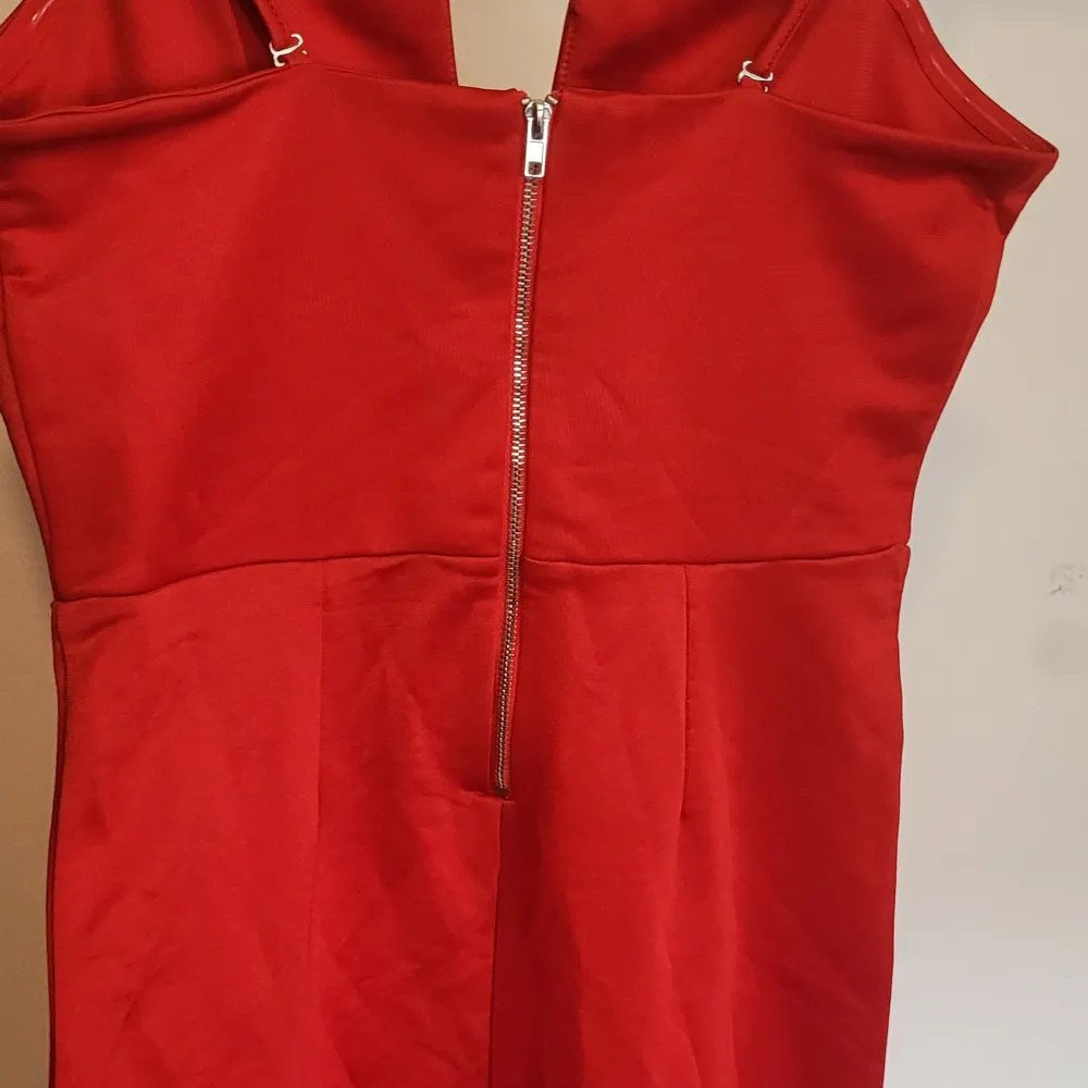 supersnygg röd klänning med fin detalj vid brösten och dragkedja i ryggen. klänningen går en bit över knäna på mig som är 160 cm lång . Klänningar.