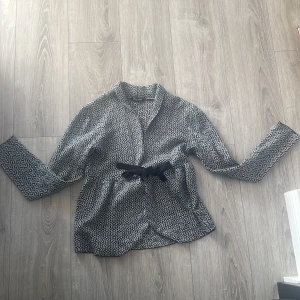 En fin kofta - En kofta som är vit och svart med ett fint mönster.