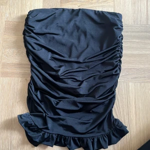 Kjol Hannah Schönberg x NA-KD - Kjol med volang. Från kollektion av Hanna Schönberg för NAKD. Resår i midjan och silikon vid slut för bra passform. Längd: Midi